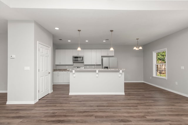 kitchen with a kitchen breakfast bar, dark wood-type flooring, white cabinets, white appliances, and a kitchen island with sink