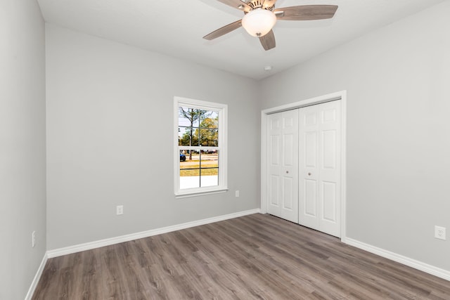 unfurnished bedroom with ceiling fan, a closet, and hardwood / wood-style floors