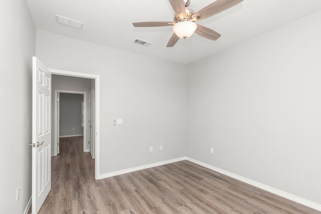 spare room with ceiling fan, hardwood / wood-style floors, and a textured ceiling