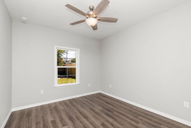 empty room with ceiling fan and dark hardwood / wood-style flooring