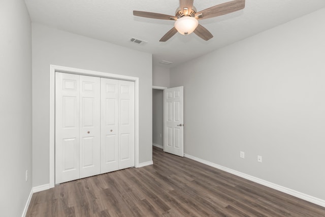 unfurnished bedroom featuring a closet, ceiling fan, a textured ceiling, and dark hardwood / wood-style flooring