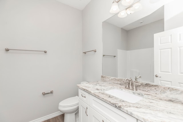 bathroom featuring vanity, toilet, and hardwood / wood-style flooring