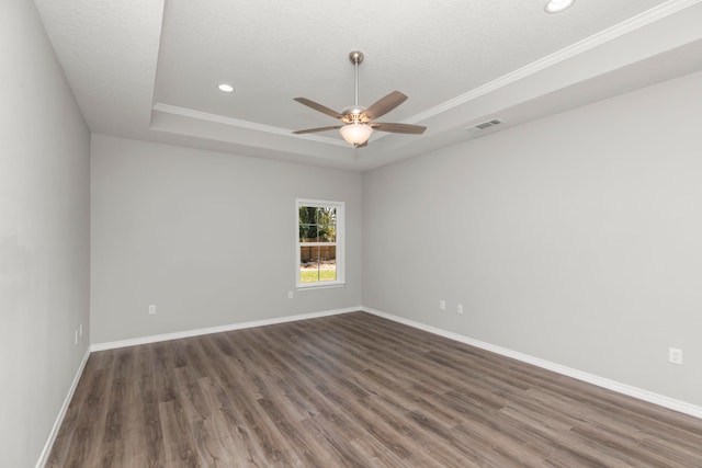 unfurnished room featuring ornamental molding, ceiling fan, a raised ceiling, and dark wood-type flooring