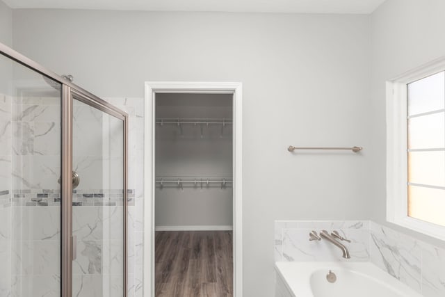 bathroom with wood-type flooring and plus walk in shower