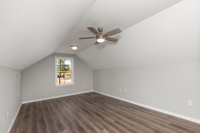 additional living space featuring ceiling fan, a textured ceiling, lofted ceiling, and dark hardwood / wood-style flooring