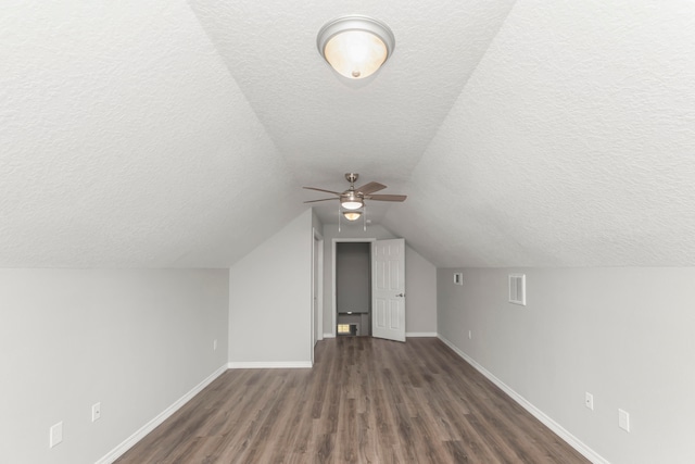 bonus room featuring ceiling fan, a textured ceiling, lofted ceiling, and dark hardwood / wood-style flooring