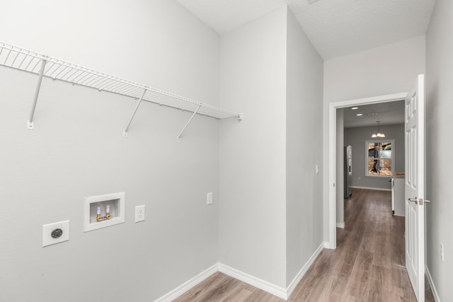 laundry room featuring washer hookup, hookup for an electric dryer, a textured ceiling, and hardwood / wood-style floors