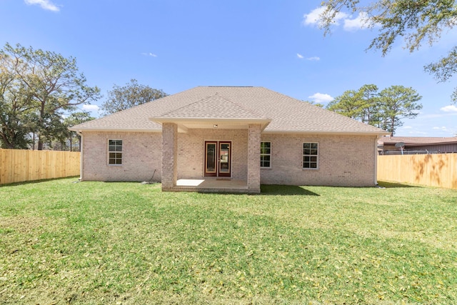 rear view of house featuring a yard