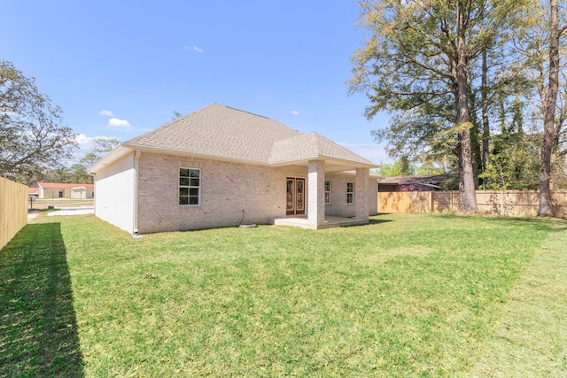 rear view of house featuring a patio area and a yard