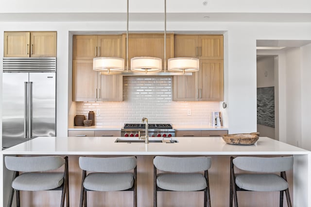 kitchen with a kitchen breakfast bar, tasteful backsplash, and an island with sink