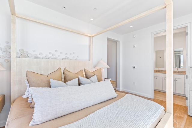 bedroom featuring light hardwood / wood-style floors, sink, and ensuite bathroom