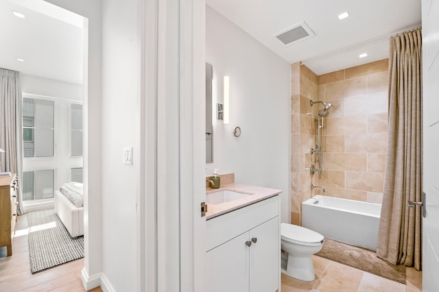 full bathroom with shower / bath combo with shower curtain, toilet, tile floors, and vanity