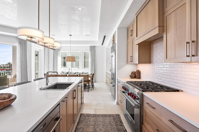 kitchen featuring light tile flooring, tasteful backsplash, high quality appliances, sink, and pendant lighting