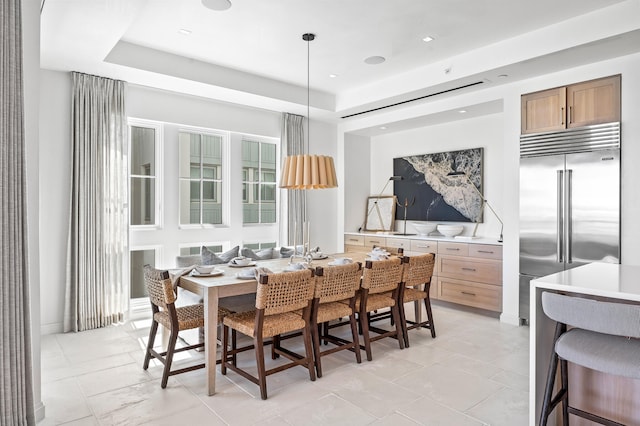 tiled dining room with a tray ceiling