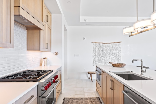 kitchen with decorative light fixtures, light tile flooring, appliances with stainless steel finishes, sink, and tasteful backsplash