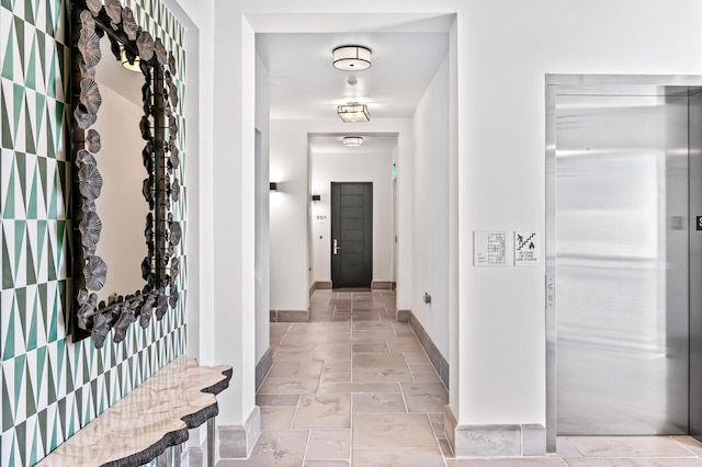 hallway featuring elevator and light tile floors