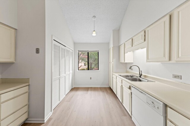 kitchen with decorative light fixtures, light hardwood / wood-style flooring, sink, dishwasher, and a textured ceiling