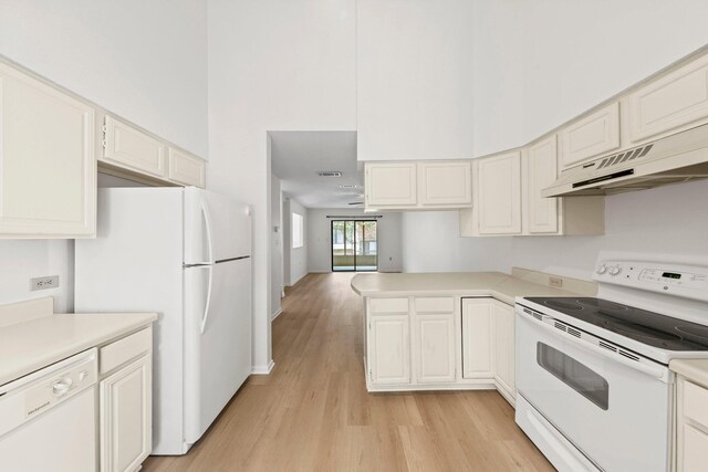 kitchen with white cabinets, white appliances, and light wood-type flooring