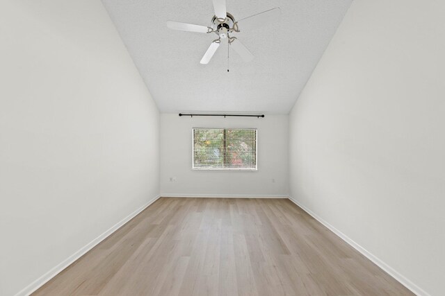 empty room featuring light hardwood / wood-style floors, ceiling fan, and a textured ceiling