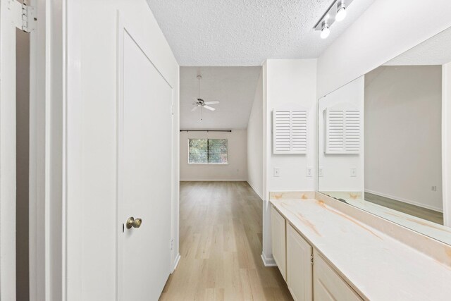 corridor featuring light hardwood / wood-style floors and a textured ceiling