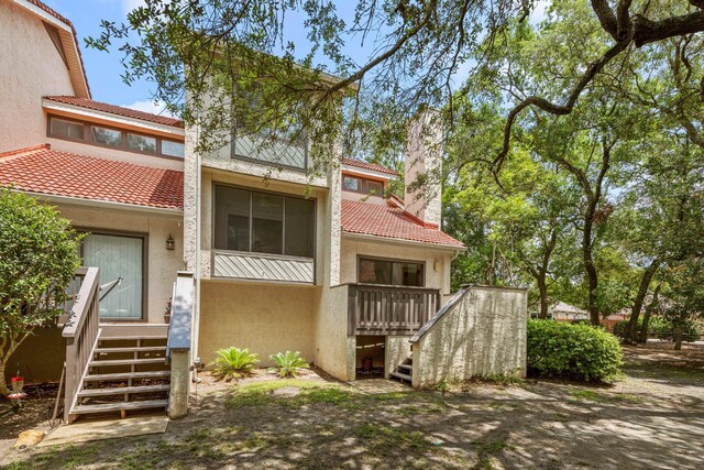 rear view of property featuring a wooden deck