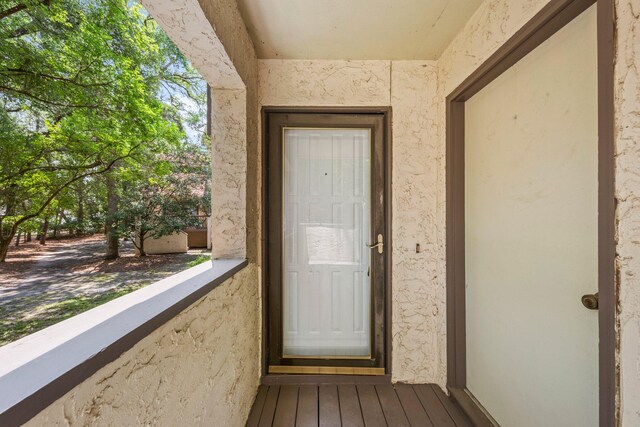 view of exterior entry with a balcony