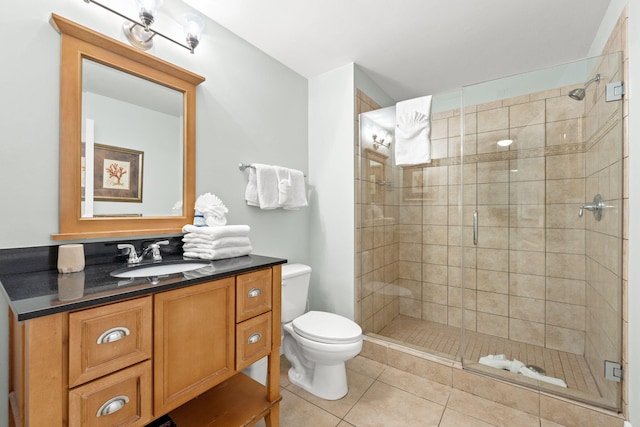 bathroom featuring a shower with door, oversized vanity, tile floors, and toilet