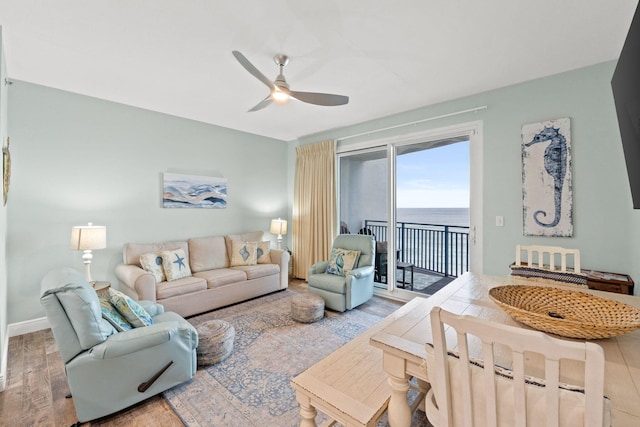 living room with a water view, light hardwood / wood-style flooring, and ceiling fan