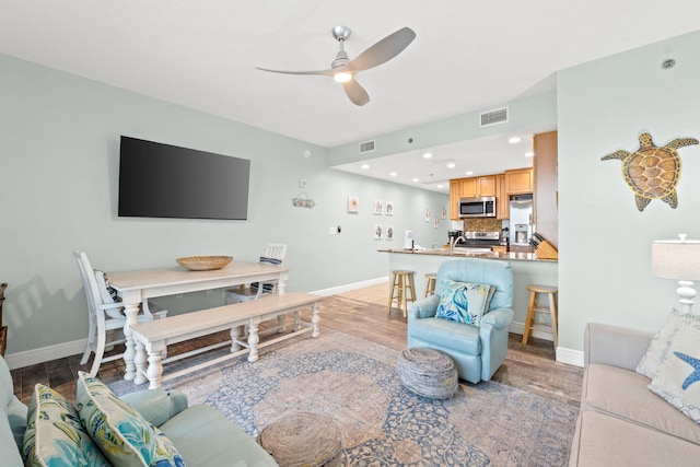 living room with light hardwood / wood-style floors and ceiling fan