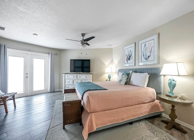 bedroom featuring french doors, ceiling fan, access to exterior, dark hardwood / wood-style floors, and a textured ceiling