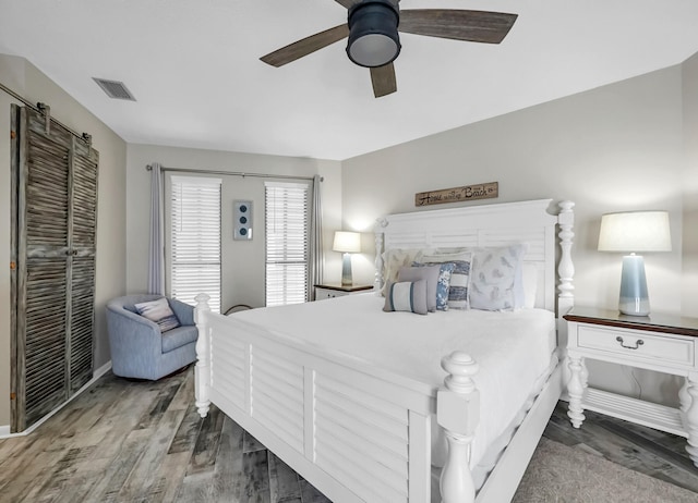 bedroom with ceiling fan and dark wood-type flooring