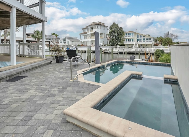 view of pool with a water view, an in ground hot tub, and a patio area