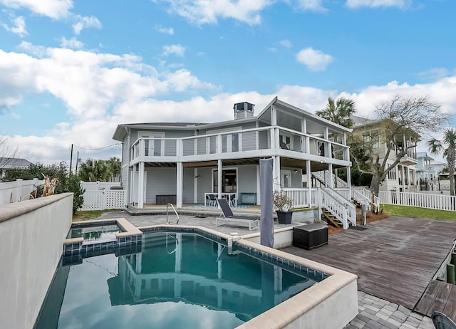 rear view of house featuring a swimming pool with hot tub and a patio