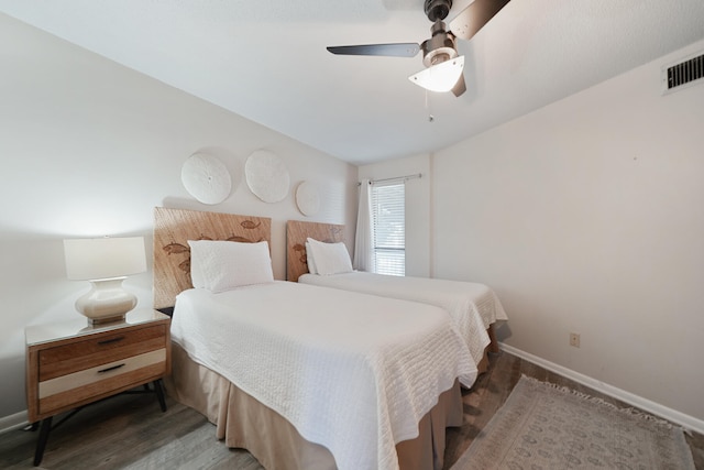 bedroom with ceiling fan and dark wood-type flooring