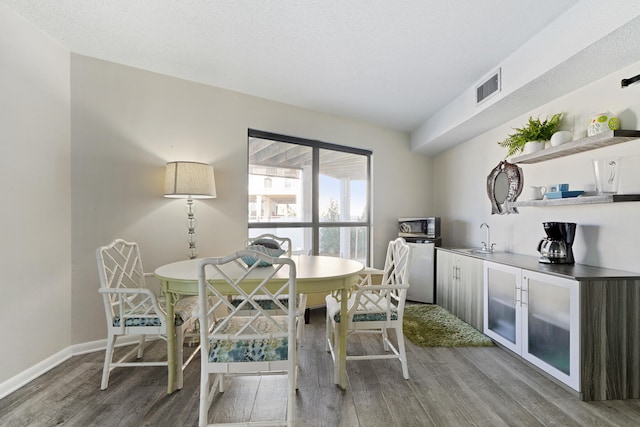 dining area with hardwood / wood-style flooring and sink