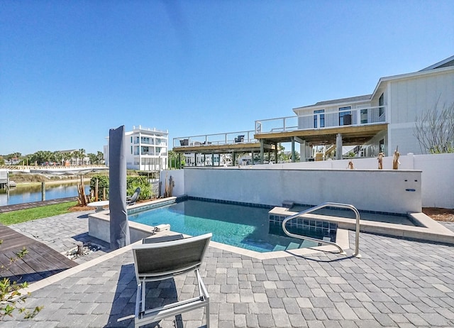 view of pool with a patio and a water view