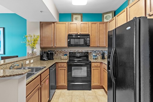 kitchen featuring light stone counters, black appliances, kitchen peninsula, sink, and light tile floors