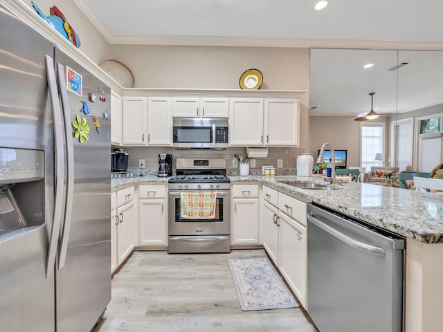 kitchen featuring stainless steel appliances, decorative backsplash, light wood-type flooring, sink, and light stone counters