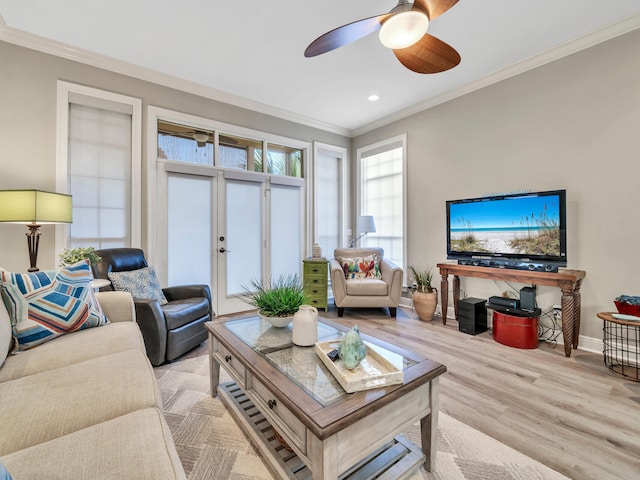 living room featuring light hardwood / wood-style floors, ceiling fan, and crown molding