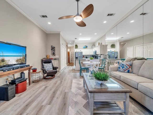 living room with ceiling fan, light wood-type flooring, and crown molding