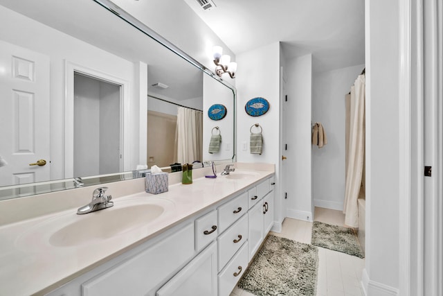 64 Vantage Pt Unit 64, Miramar Beach, FL 32550 - bathroom with double vanity, a sink, baseboards, and visible vents
