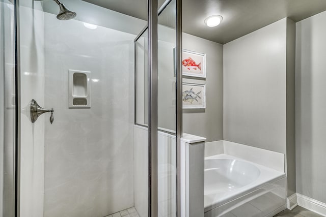 bathroom with tile flooring and separate shower and tub