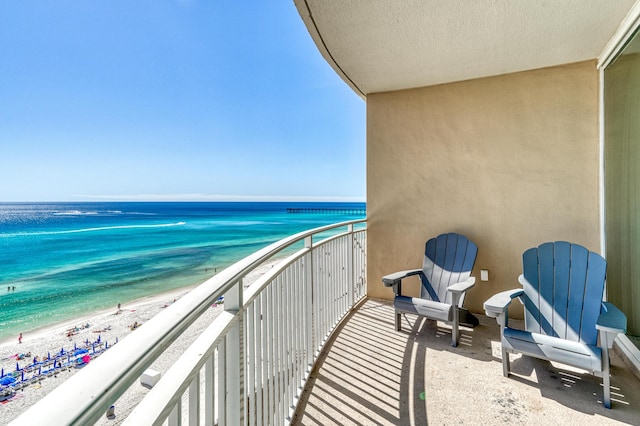 balcony with a water view and a beach view