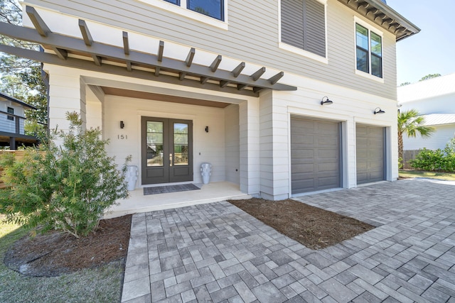 property entrance with a garage and french doors