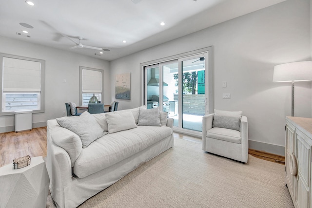 living room featuring light hardwood / wood-style flooring and ceiling fan