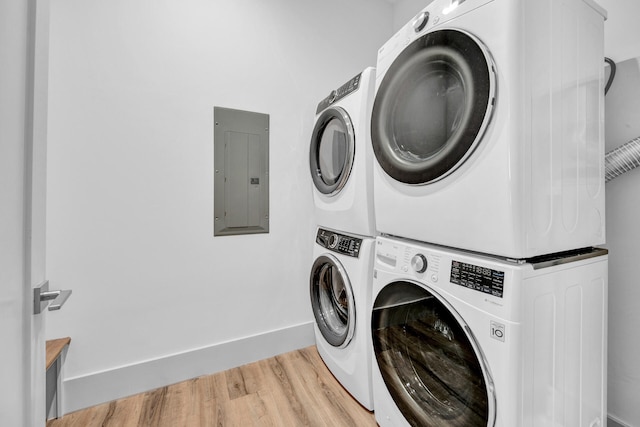 washroom featuring light hardwood / wood-style floors and stacked washer and dryer