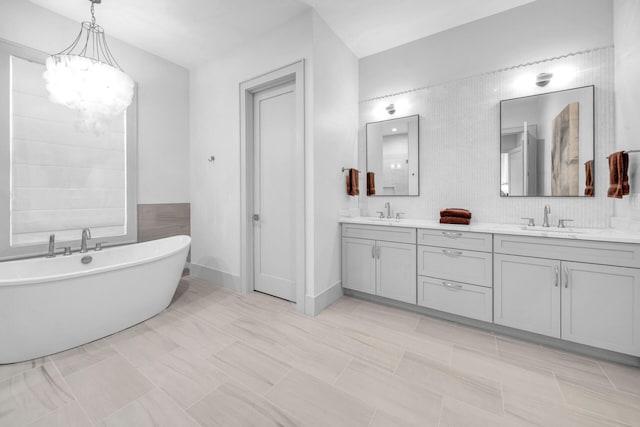 bathroom featuring tile flooring, large vanity, dual sinks, backsplash, and a bath to relax in