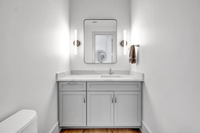 bathroom featuring hardwood / wood-style floors, vanity, and toilet