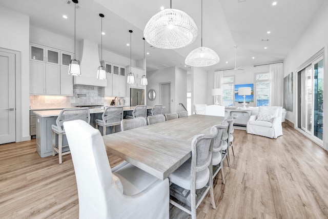 dining space featuring a wealth of natural light, light hardwood / wood-style flooring, and high vaulted ceiling