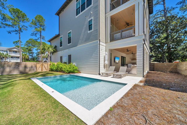 view of swimming pool with ceiling fan, a yard, and a patio